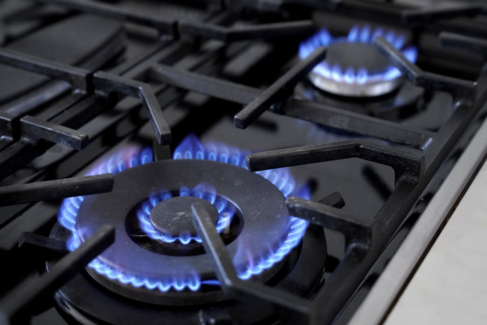 Flames emerge from burners on a gas stove. 