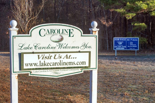 Just beyond a Lake Caroline welcome sign sits a "for sale" sign for commercial use seen Thursday. Residents of the Madison neighborhood are protesting a potential new gas station and restaurant north of Stripling Road, just east of the neighborhood entrance, .