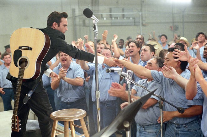 Joaquin Phoenix, portraying Johnny Cash, shakes hands with "inmates" as he performs at Folsom Prison in a scene from "Walk the Line." The Pipkin Building in Memphis was transformed into Folsom Prison for the movie.